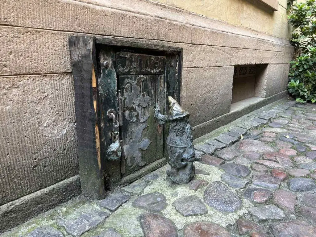 Kleine Zwergenfigur aus Bronze auf dem Boden einer Altstadtgasse in Breslau