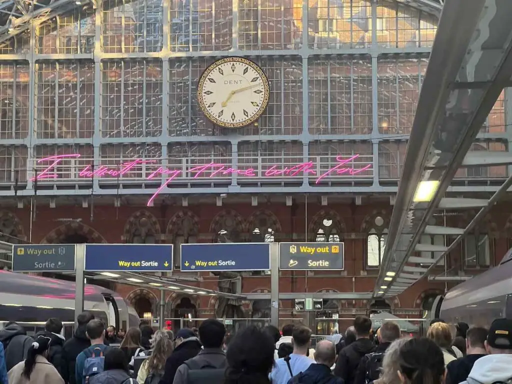 Bahnhofshalle im Bahnhof St. Pancras in London mit großer Uhr vielen Menschen