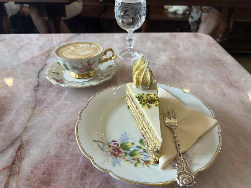 Kunstvoll verziertes Stück Kuchen mit einer Tasse Kaffee in der Konditorei Kormuth in Bratislava