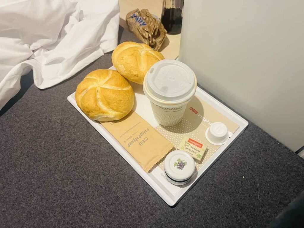 Frühstück in der Mini Cabin stehend auf einem kleinen Tablett mit Brötchen, Marmelade und Kaffee.