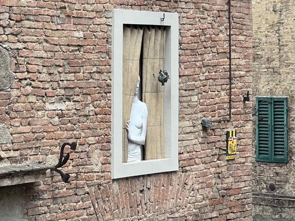 Frauenstatue im Fenster in Siena