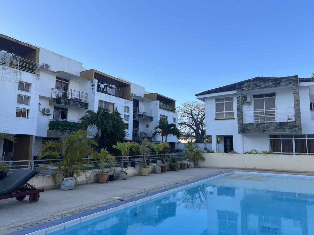 Häuserfront in Mombasa mit kleinen Balkon und im Vordergrund ein kleiner Pool.
