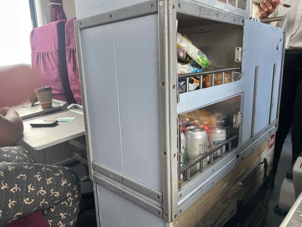 Snackwagen im Gang gefüllt mit Getränken und Essen.