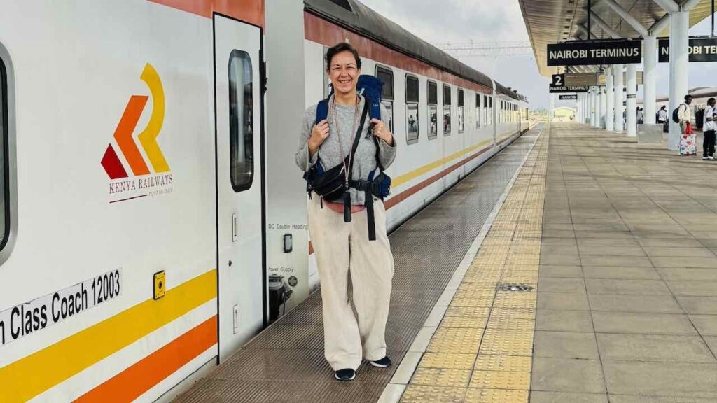 Zugfräulein vor dem Zug am Bahnsteig von Nairobi