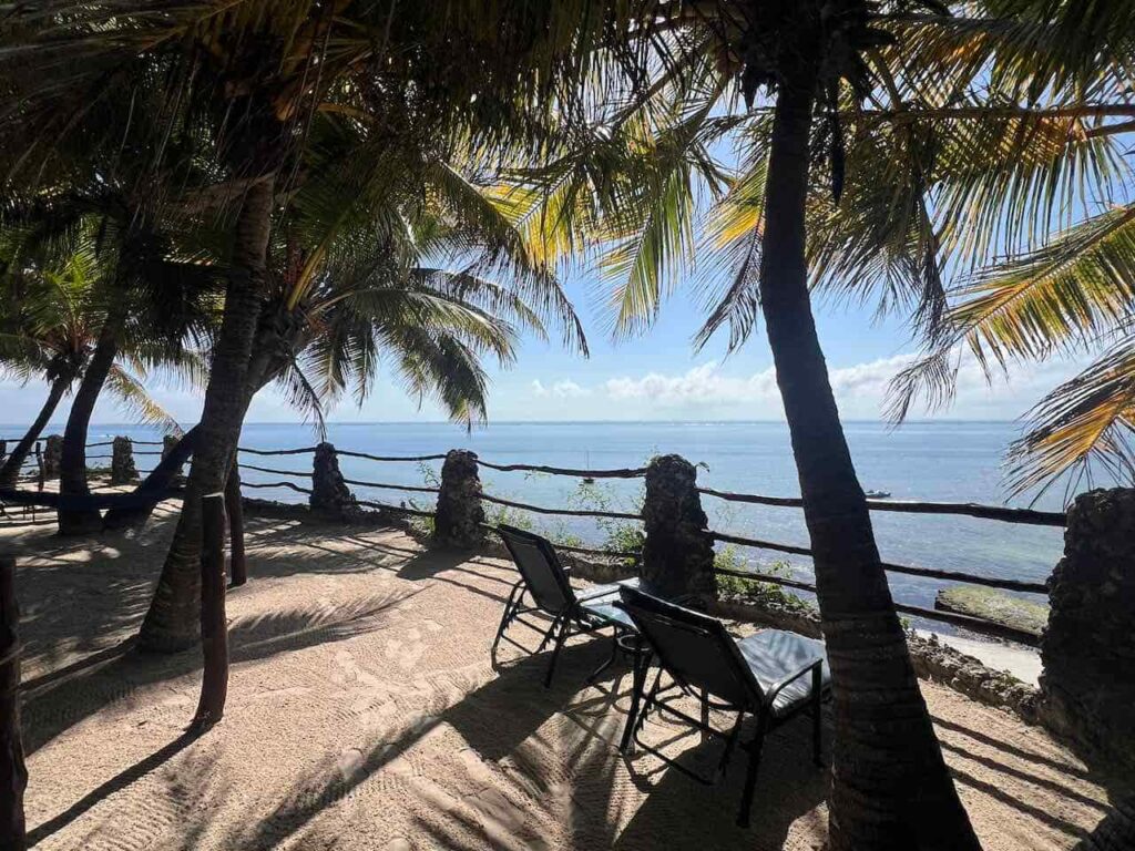 Nyali Beach bei Mombasa mit Palmen und Liegestühlen im Vordergrund und im Hintergrund das blaue Meer