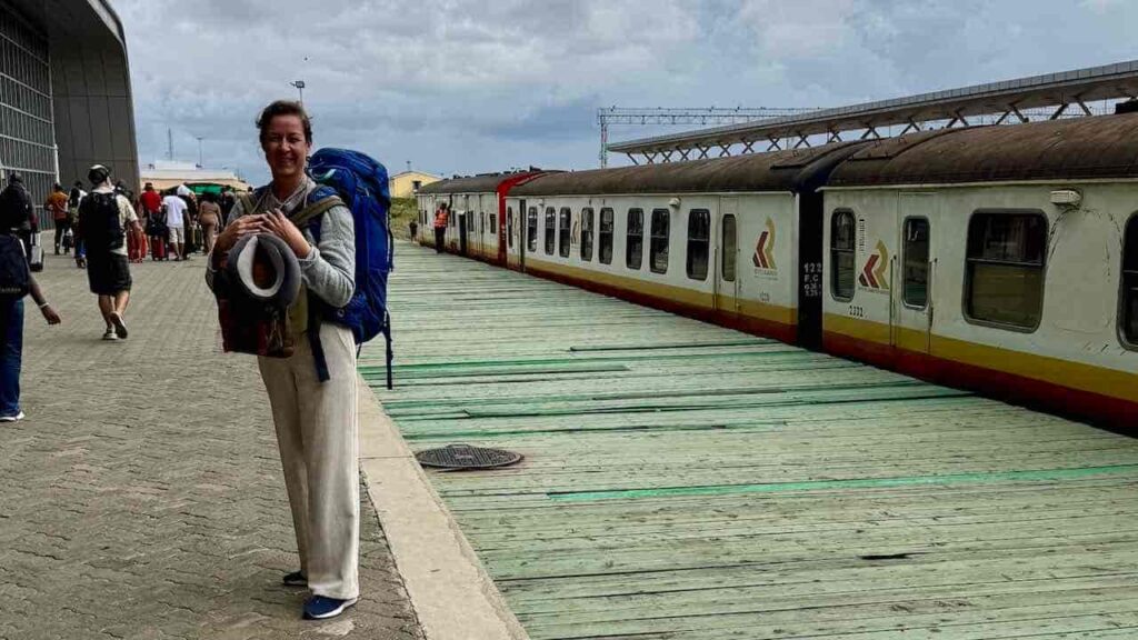 Am Bahnhof von Nairobi stehend mit einem Zug im Hintergrund