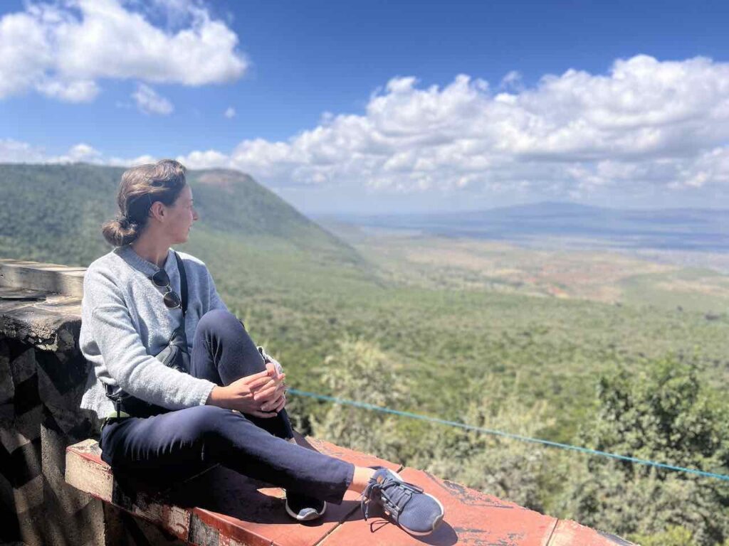 Auf einem Felsvorsprung sitzend am Great Rift Valley View Point in Kenia.