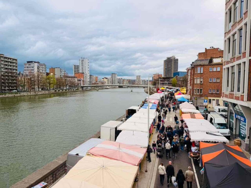 Blick auf die Maas und den Marché de la Batte mit vielen Marktständen.